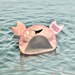May include: Pink crab-shaped pool float with a mesh net in the center and the name "Bella" embroidered on one of the crab claws.