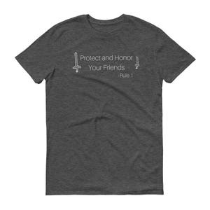 May include: Dark gray t-shirt with the text "Protect and Honor Your Friends - Rule 1" in white. The design includes two stylized sword illustrations, one on each side of the text. The shirt is made of a soft material.