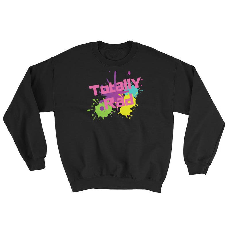 May include: Black sweatshirt with the text "Totally Rad" in pink, yellow, and blue, with matching paint splatter designs. The sweatshirt has long sleeves and a crew neck.