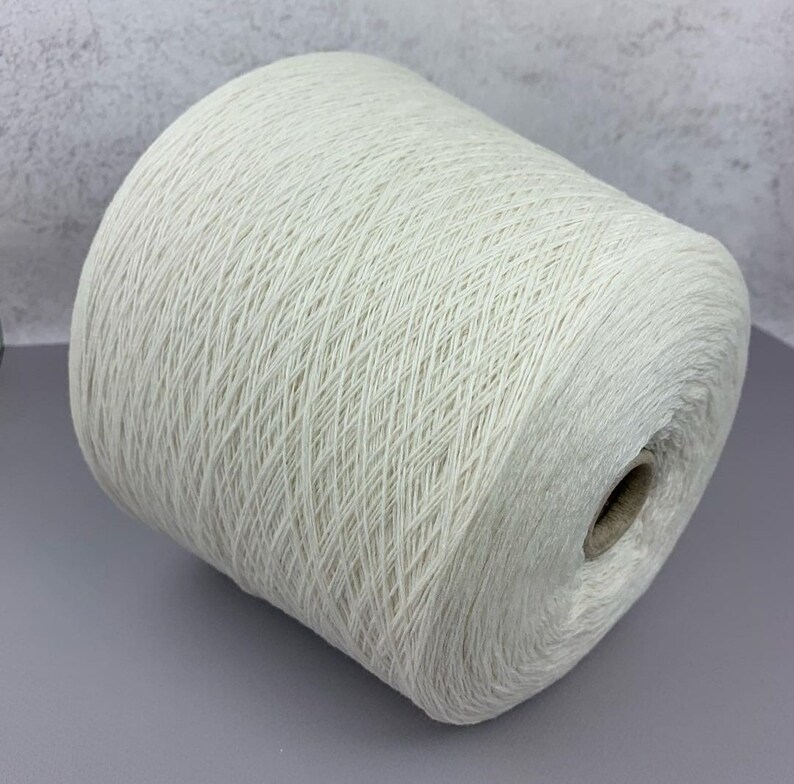 May include: A skein of off-white yarn wound on a cardboard tube.