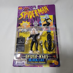 May include: Black Cat action figure from the Spider-Man animated series. The figure is wearing a black suit with white fur trim and comes with a crossbow accessory. The packaging features a bonus collector pin.