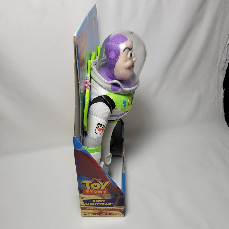 Peut inclure: Un jouet en peluche Buzz l'&Eacute;clair de la franchise Toy Story de Disney Pixar. Le jouet est enti&egrave;rement articul&eacute; et pr&eacute;sente un casque violet avec une visi&egrave;re transparente, une combinaison spatiale verte et blanche et un badge en forme d'&eacute;toile blanc et rouge sur le bras. Le jouet est emball&eacute; dans une bo&icirc;te en carton avec un design bleu et rouge.