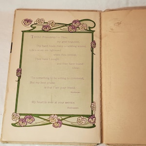 May include: Open book with a poem on the left page. The poem is framed with a green border and floral accents in purple and white. The text includes the words "Friendship!" and "Shakespeare."