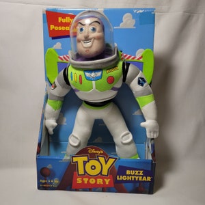 Peut inclure: Un jouet en peluche Buzz l'&Eacute;clair de Toy Story de Disney. Le jouet est enti&egrave;rement articul&eacute; et porte une combinaison spatiale verte et blanche avec un sous-v&ecirc;tement violet. Le jouet est dans son emballage d'origine, qui pr&eacute;sente le logo Toy Story et les mots "Buzz l'&Eacute;clair".
