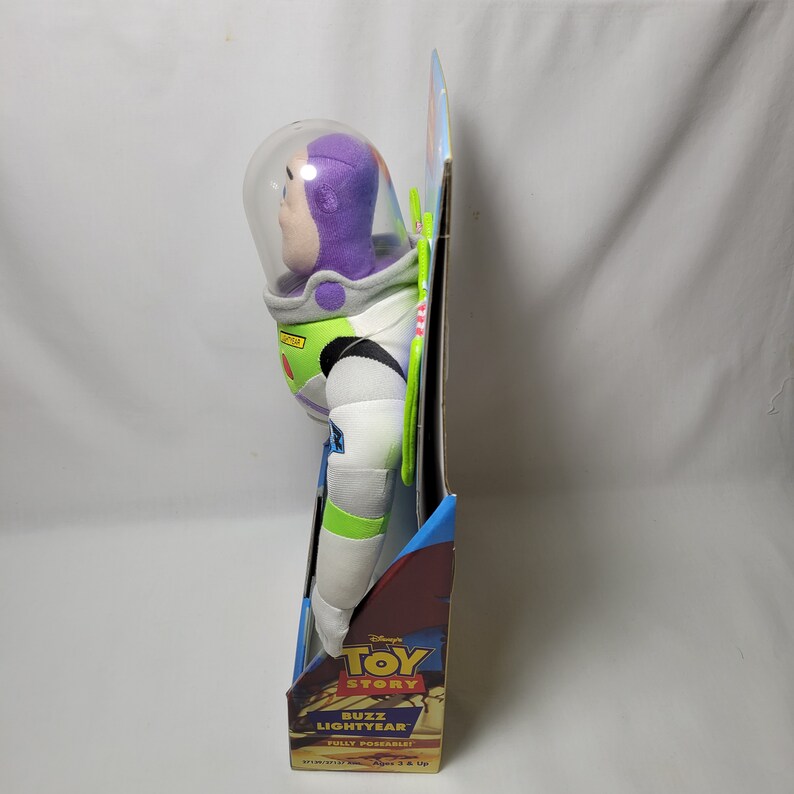 Peut inclure: Un jouet en peluche Buzz l'&Eacute;clair de la franchise Toy Story de Disney Pixar. Le jouet est enti&egrave;rement articul&eacute; et pr&eacute;sente un casque violet, une combinaison spatiale verte et blanche et un badge de ranger spatial jaune. Le jouet est emball&eacute; dans une bo&icirc;te avec un fond bleu et rouge et le logo Toy Story.