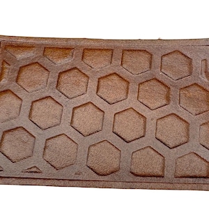 May include: A brown leather doormat with a honeycomb pattern.