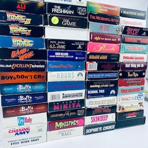 May include: A stack of VHS tapes featuring popular movies from the 1990s and early 2000s, including "The Freshman", "Groundhog Day", "Thelma & Louise", "Saving Private Ryan", "Buffy the Vampire Slayer", "Mallrats", and "Monster's Ball".