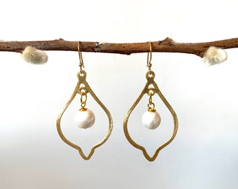 May include: Gold earrings with a teardrop-shaped design and a single white pearl hanging from each earring.