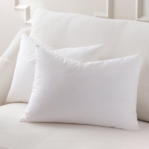 May include: Two white pillowcases on a white couch. The pillowcases are made of a soft, smooth fabric.