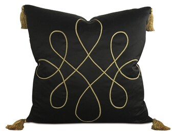 May include: Black pillow with gold embroidered design and tassels.