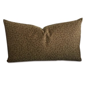 May include: A brown lumbar pillow with a beige leaf pattern.