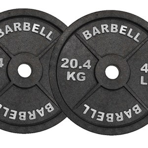 May include: Two black barbell weight plates. Each plate is round with the word "BARBELL" in raised white letters. One plate is marked "20.4 KG" and the other is marked "45 LB". The plates have a central hole and a cross-shaped design.