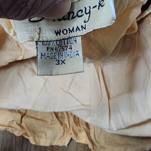 May include: A beige cotton top with a white tag that says "Fancy-k Woman 100% Cotton RH6/574 Made in India 3X".