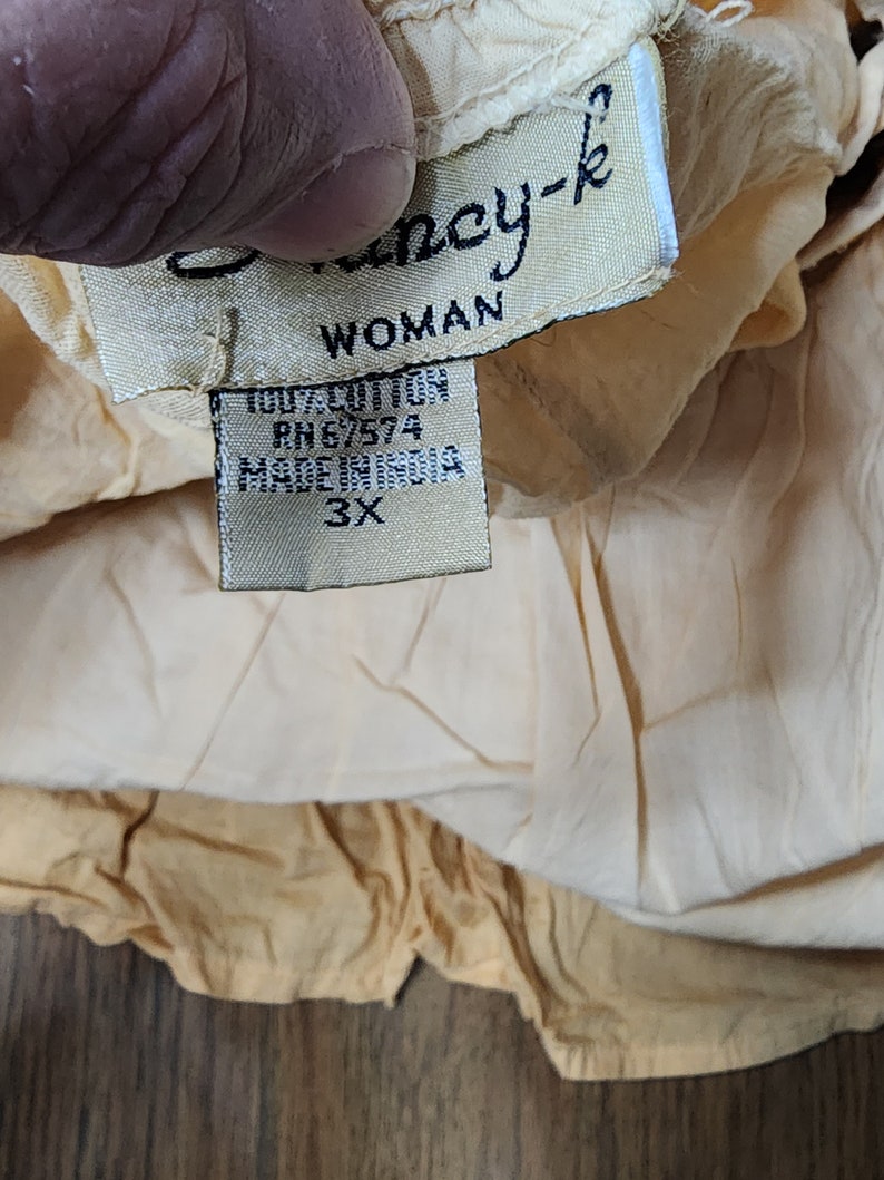 May include: A beige cotton top with a white tag that says "Fancy-k Woman 100% Cotton RH6/574 Made in India 3X".