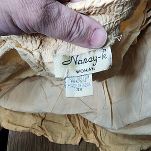 May include: A yellow cotton skirt with a label that reads "Nancy-k Woman 100% Cotton RN#67574 Made in India 3X".