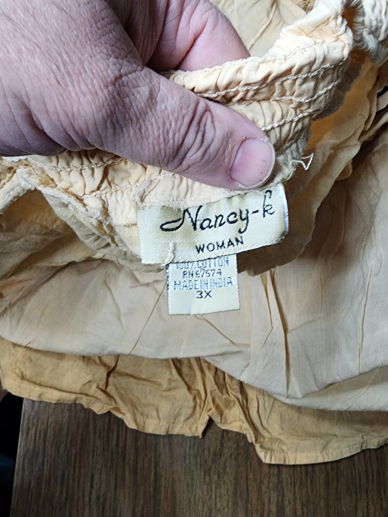 May include: A yellow cotton skirt with a label that reads "Nancy-k Woman 100% Cotton RN#67574 Made in India 3X".
