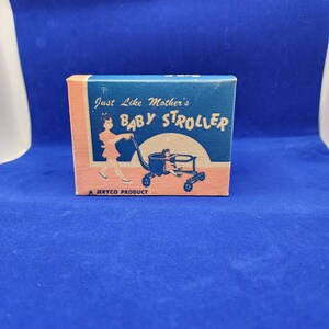 May include: A vintage baby stroller box in blue and peach. The box has the text "Just Like Mother's Baby Stroller" and an illustration of a woman pushing a stroller. It is labelled "A JERYCO PRODUCT".