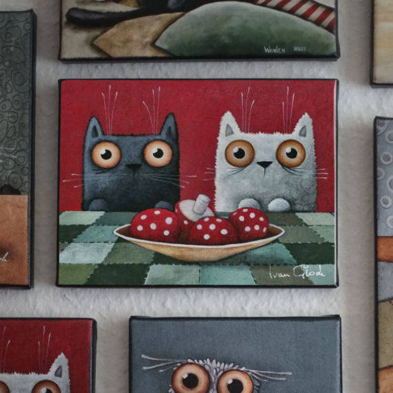 Puede incluir: Una pintura de dos gatos, uno negro y otro blanco, sentados a una mesa con un plato de champi&ntilde;ones rojos y blancos. El fondo es un patr&oacute;n de cuadros rojos. La pintura est&aacute; firmada "Ivan Glod".