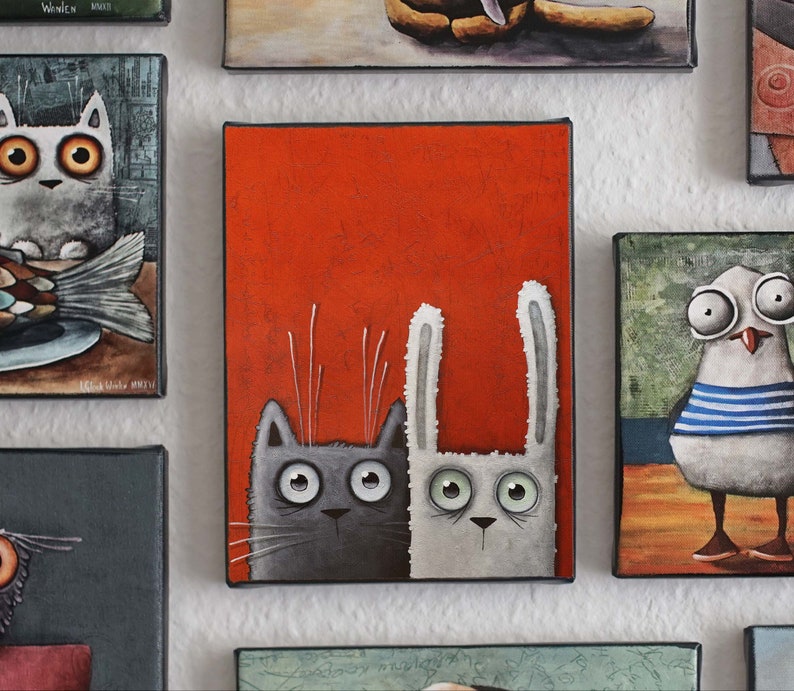May include: A painting of a gray cat and a white rabbit with big eyes, looking at the viewer. The animals are on a red background.