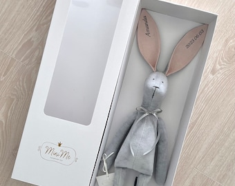 May include: A gray plush bunny with long ears, personalized with the name "Amanda" and the date "2023 06 03". The bunny is in a white gift box with a clear window.