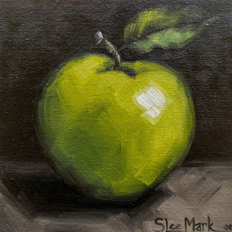 May include: A green apple with a leaf on a dark brown background. The apple has a shiny, glossy finish and a white highlight on the side.