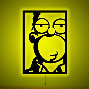 Könnte beinhalten: Eine schwarze und gelbe Silhouette einer Comicfigur mit einer großen Nase und einem überraschten Ausdruck. Die Figur ist in einem schwarzen Quadrat gerahmt.