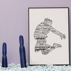 May include: A rectangular framed print featuring a black silhouette of a person jumping, filled with the lyrics to the song Footloose in black text on a white background. The silhouette depicts a dynamic pose with arms and legs extended outward.