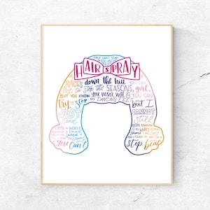 May include: A framed wall art print featuring a stylized silhouette of a bouffant hairstyle composed of colorful handwritten lyrics from the musical Hairspray. The text includes the title Hairspray in a pink bow and various song verses.
