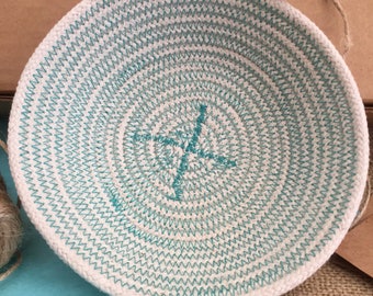 all-natural coiled rope basket with one handle and teal thread detail