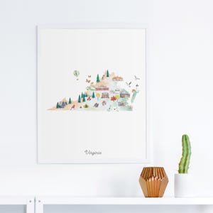 以下が含まれることがあります： バージニア州の水彩画風マップが描かれた額入りアートプリント。地図には木々、熱気球、蝶、様々な建物が描かれています。下部中央には筆記体で「Virginia」という文字が印刷されています。