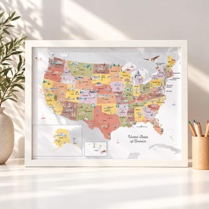 May include: A framed map of the United States of America featuring pastel-colored states, each decorated with small illustrations of regional landmarks, animals, and activities. The map includes inset boxes for Alaska and Hawaii.