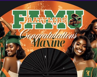 May include: A black and green graduation fan with the text "FAMU Rattlers" and "Congratulations Maxine". The fan features a black and green design with a gold snake logo. Two women in graduation robes are pictured on the fan.