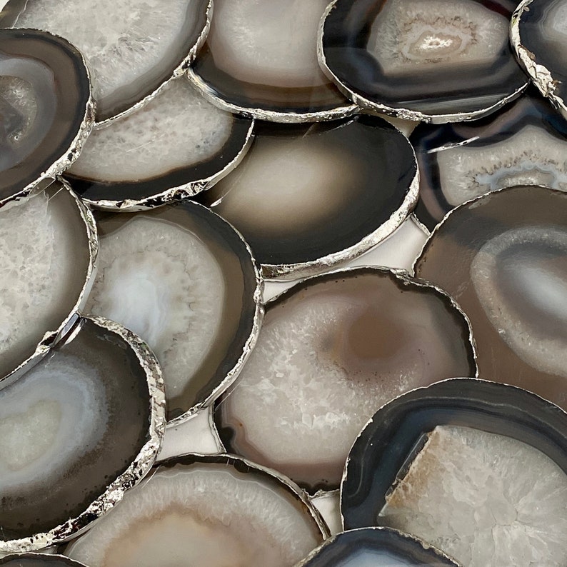 Peut inclure: Un ensemble de dessous-de-verre en agate avec une bordure argent&eacute;e. Les dessous-de-verre sont ronds et ont un aspect naturel et organique. Ils sont parfaits pour ajouter une touche d'&eacute;l&eacute;gance &agrave; n'importe quelle maison.