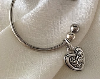Pulsera plateada con dije de corazón grabado