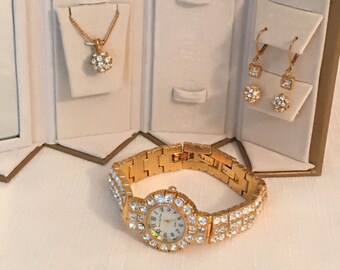 Conjunto de joyas de cristal vintage: reloj, pendientes y collar en tono dorado.