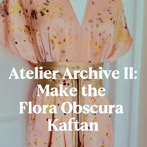 Op de afbeelding: Een lichtroze kaftan met een verspreide botanische print in bruine, gele en paarse tinten, in de taille samengebonden met een brede gouden sjerp. De tekst "Atelier Archive II: Make the Flora Obscura Kaftan" staat over het kledingstuk heen.