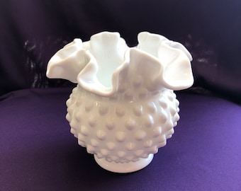 May include: A white milk glass vase with a ruffled top and a textured, dotted surface.
