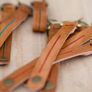 Dunne rode lijn sleutelhangers met antiek messing afwerking sleutelhanger en drukknopen