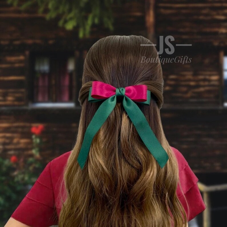 Pode incluir: Um prendedor de cabelo de fita de cetim verde e rosa. O la&ccedil;o &eacute; amarrado em um estilo cl&aacute;ssico com caudas longas. O prendedor de cabelo &eacute; perfeito para adicionar um toque de eleg&acirc;ncia a qualquer penteado.