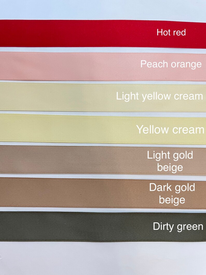 Pode incluir: Uma cole&ccedil;&atilde;o de sete fitas de cetim de diferentes cores, incluindo vermelho quente, laranja p&ecirc;ssego, creme amarelo claro, creme amarelo, bege dourado claro, bege dourado escuro e verde sujo.