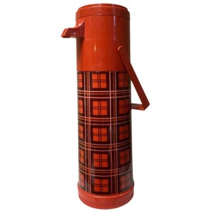 Könnte beinhalten: Eine rote Vintage-Thermoskanne mit einem Karomuster in Rot- und Brauntönen. Die Thermoskanne hat einen Griff und einen Ausguss zum Ausgießen. Die Thermoskanne ist zylindrisch und scheint aus Kunststoff zu sein.