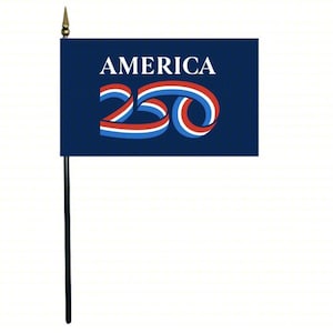 May include: A small flag with a dark blue background. The word "AMERICA" is in white block letters at the top. Below, the number "250" is stylized with red, white, and blue ribbons. The flag is mounted on a black pole with a gold spear-shaped finial.