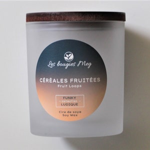 Peut inclure: Un bocal en verre givré avec un couvercle en bois. L'étiquette indique "Les bougies Meg", "CÉRÉALES FRUITÉES", "Fruit Loops", "FUNKY collection", "LUDIQUE", "Cire de soya", et "Soy Wax".
