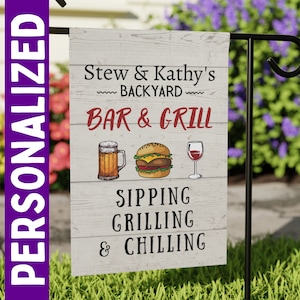 May include: A white wooden sign with the text "Stew & Kathy's Backyard Bar & Grill Sipping Grilling & Chilling" in red and black lettering. The sign features a cartoon image of a beer, hamburger, and glass of wine.