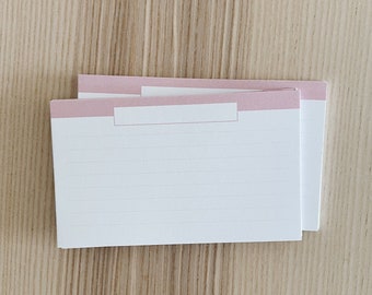 Peut inclure: Deux cartes de recette blanches avec une bande rose et un espace blanc vide en haut. Les cartes sont lignées de fines lignes grises.