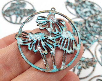 May include: A set of turquoise and copper metal charms with a floral design. The charms are round and have a cutout design. The charms are perfect for jewelry making or other craft projects.