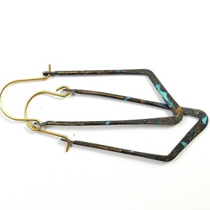 May include: A pair of geometric shaped earrings with a brass hook and a blue and brown patina finish.