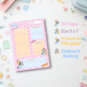 May include: A daily planner notepad with a pink paw print background, featuring sections for to-do lists, goals, reminders, and notes. The planner includes cartoon dog illustrations, 50 pages, a 5 x 7 inch size, 24lb paper, and chipboard backing.
