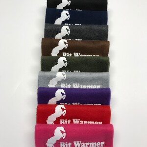 May include: A stack of ten fleece horse bit warmers in various colours, including black, navy blue, grey, brown, green, purple, red, and pink. Each warmer features a white horse silhouette and the text "Bit Warmer".