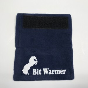 May include: A navy blue fleece bit warmer with a white horse logo and the text "Bit Warmer". The warmer has a black velcro strap.
